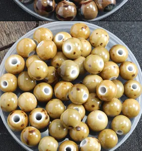 Gros plan de perles en ceramique emaillee mixee pour fabrication de bijoux et accessoires DIY.