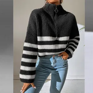 Detail view of black and white striped knit sweater, featuring zip turtleneck and long sleeves.