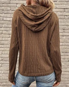 Gedetailleerd overzicht van de bruine kabelgebreide hoodie met focus op de achterkant.
