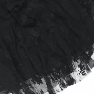 Detail van zwarte kantstof met geruwde mesh-lagen en een fijn getextureerd patroon dichtbij.