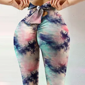 Detail view of tie dye yoga pants with bow, high waist butt lift fitness leggings for women.
