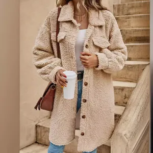 Closeup shot of a cozy long teddy fleece coat with lapel collar and buttons in neutral beige.