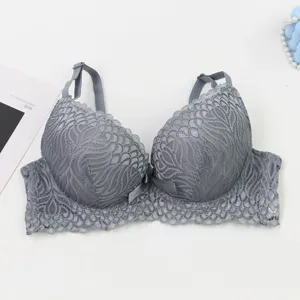 Close-up of grey lace bra detail, featuring delicate floral pattern and adjustable straps.