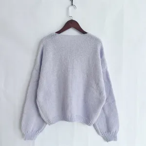 Vista detallada de la espalda de un suéter de punto morado liso, textura suave y casual.