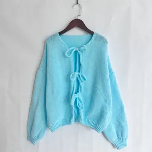 Detalle de cárdigan de punto azul claro, cierre de lazo delantero, suéter suave de manga larga.