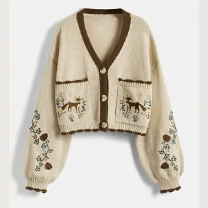 Détail cardigan en tricot beige, poches brodées de renard, col V marron, manches longues.