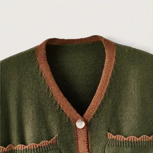 Gros plan sur les details du gilet en maille avec col V contrasté et poches avant.