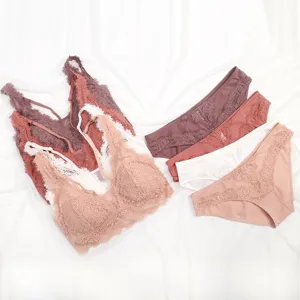 Detailaufnahme von zartem Spitzen-Bralette und passendem Slip in verschiedenen Farben.