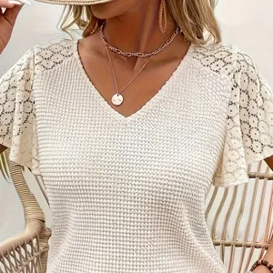 Weisses V-Ausschnitt Stricktop mit feinen Spitzeneinsaetzen und strukturierter Detailansicht.