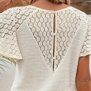 Detailansicht des eleganten weißen Häkelspitzen-Oberteils mit Rückenausschnitt und Knöpfen.