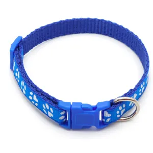 Close-up detail of the blue pet collar featuring white paw print patterns and durable buckle.