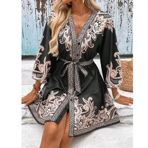 Detailed view of the stylish V-neck half-sleeve tie-belt paisley print dress outdoors.