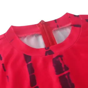 Tie-dye dress collar and zipper detail close-up view showing vibrant red pattern.
