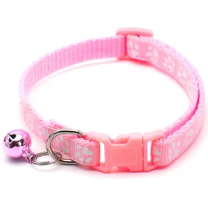 Close up view of the pink pet collar featuring cute paw patterns and a shiny bell accessory.