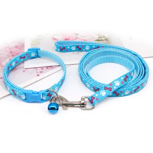 Detailed shot of blue pet collar and leash set featuring cute paw and bone prints with bell.