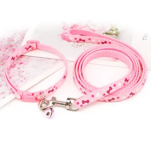 Pink pet collar and leash set with cute bone paw print design, bell and adjustable buckle.