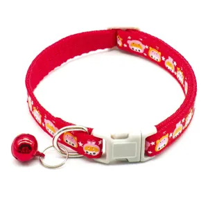 Detail shot of red pet collar with cute cartoon pattern, white buckle and red bell for small cats dogs.