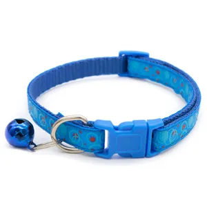 Close-up detail of blue pet collar featuring cute bubble print, metal bell, and sturdy buckle.