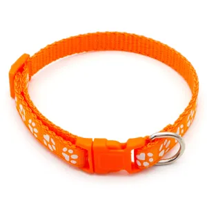 Close-up detail shot of orange pet collar featuring white paw print pattern and durable buckle.
