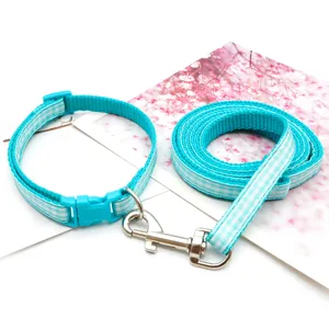 Blue plaid pet collar and leash detail view, showing durable woven fabric and sturdy metal hook.