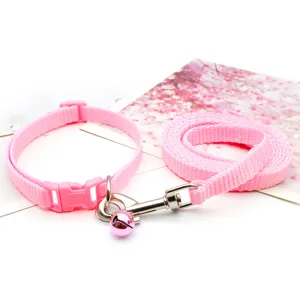 Pink pet collar and leash set detail view, featuring durable nylon strap and a cute bell.