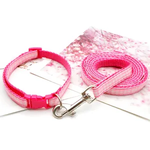 Pink plaid pet collar and leash set detail, featuring soft webbing and durable metal hardware.