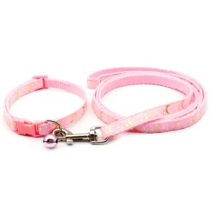 Détail d'ensemble collier et laisse rose avec motif lune et étoiles dorées pour vos promenades.