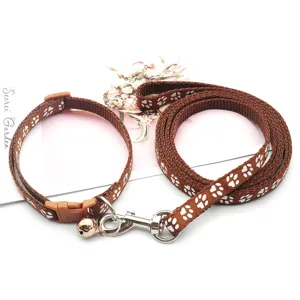 Nahaufnahme des braunen Haustierhalsbands und der Leine mit niedlichen weißen Pfotenmustern.