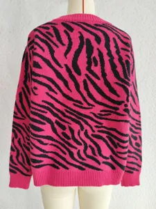 Detail view of women's long sleeve pink and black zebra stripe knit sweater pullover.