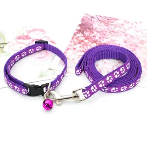 Dettaglio del set collare e guinzaglio per cani viola con simpatiche impronte di zampe bianche.