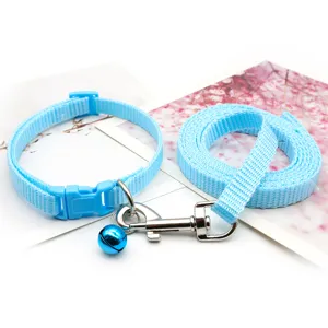 Close-up detail of light blue pet collar and matching leash set with metal bell clasp.