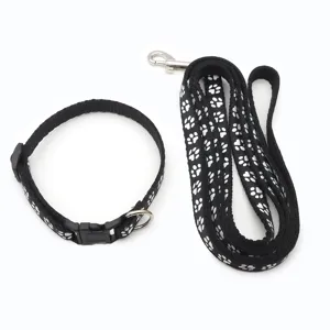 Set guinzaglio e collare nero per animali con simpatiche impronte bianche. Dettaglio.