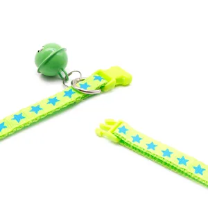 Green pet collar detail with blue stars, plastic buckle, and a large bell for small dogs.