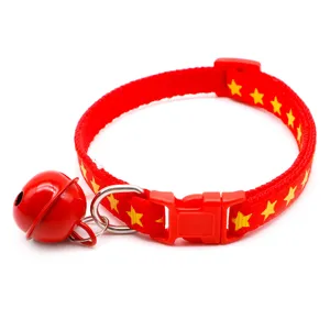 Red pet collar with yellow stars, featuring a metal bell and buckle for small cats and dogs detail view.