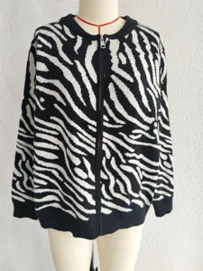 Close-up of black and white zebra pattern knitted cardigan sweater with front zip detail.