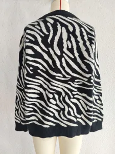 Detail view of women's black and white zebra pattern knitted sweater, casual long sleeve round neck.