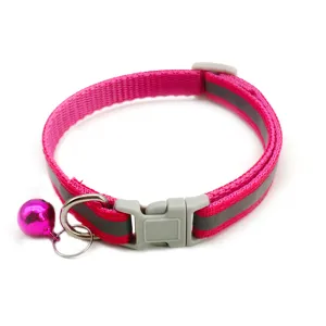 Close-up detail of the pink reflective pet collar, showing adjustable nylon strap and metal bell.