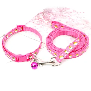 Gros plan détaillé de la laisse de chien rose et du collier de chat avec des motifs de chiots.
