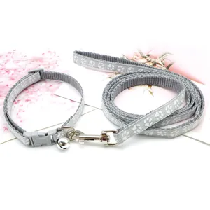 Set guinzaglio e collare grigio per animali con stampa di zampe, gancio in metallo e campanello.