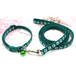 Set guinzaglio e collare verde per animali con stampa di zampe bianche e dettaglio campana.