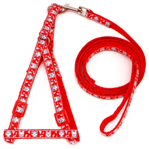 Red pet harness leash detail showing cute cat print pattern and durable metal clasp hardware.