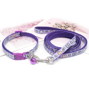 Close-up of purple pet leash and collar set, featuring cute cartoon animal print and metal bell.