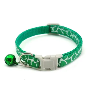 Green cracked pet collar detail, nylon strap with plastic buckle, metal D-ring and bell.