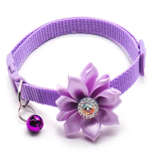 Close-up detail of purple pet collar featuring a satin fabric flower and a cute bell.