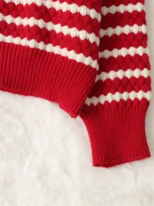 Red and white striped knitwear sweater detail showing textured pattern and ribbed cuffs.