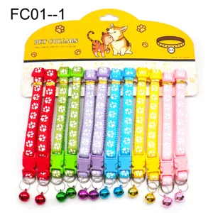 Colorful pet collar detail shot, fabric strap with cute paw prints and a ringing bell.