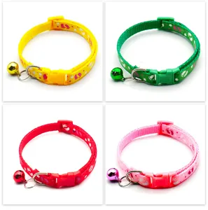 Close-up detail of colorful pet collars with cute paw prints, bells, and secure plastic buckles.