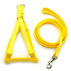 Close-up of yellow plaid pet harness and leash, featuring durable metal ring and soft strap fabric.