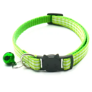 Green plaid cat collar with cute black cat face buckle and bell, detailed pet accessory view.