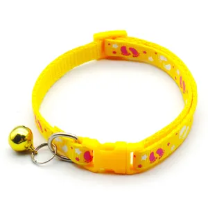 Yellow pet collar with cute paw print patterns, safety plastic buckle, and a crisp golden bell.